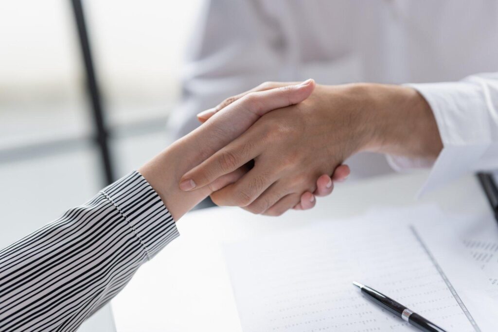 Business handshake over contract on office desk