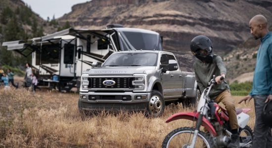 Ford Super Duty parked near caravan, dirt bike riders
